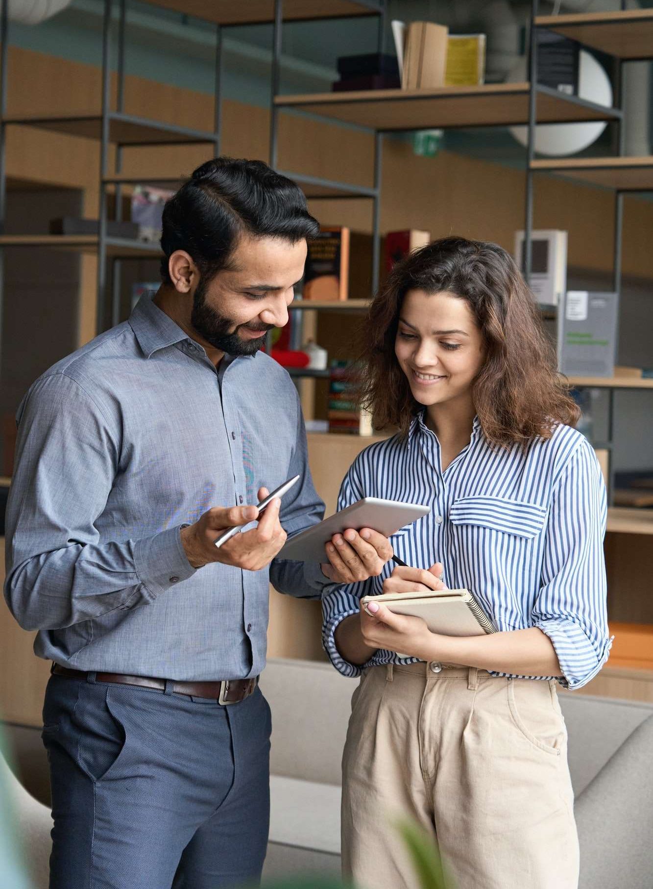 diverse-friendly-coworkers-talking-using-digital-tablet-in-office