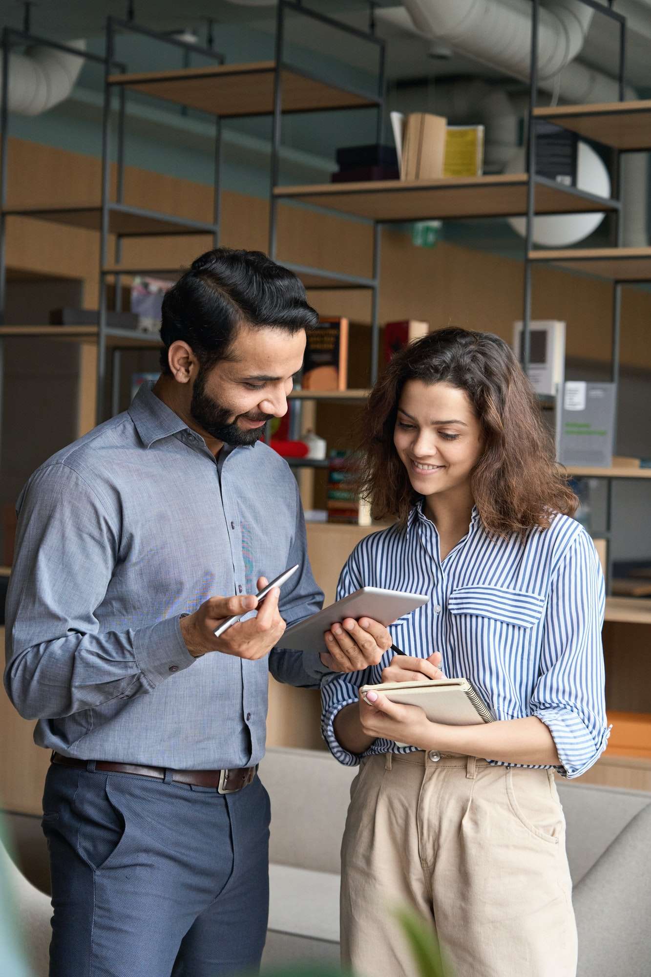 diverse-friendly-coworkers-talking-using-digital-tablet-in-office